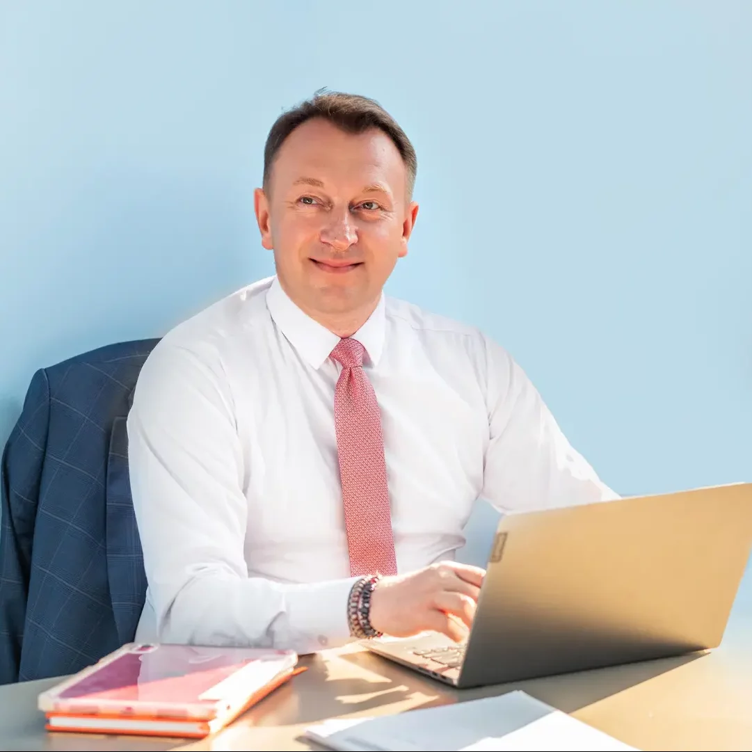 Doradca finansowy w Elblągu przy swoim biurku witający nowego klienta.